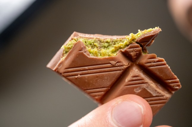 Dubai chocolate with pistachios on a plate on a white background in close-up in slow motion