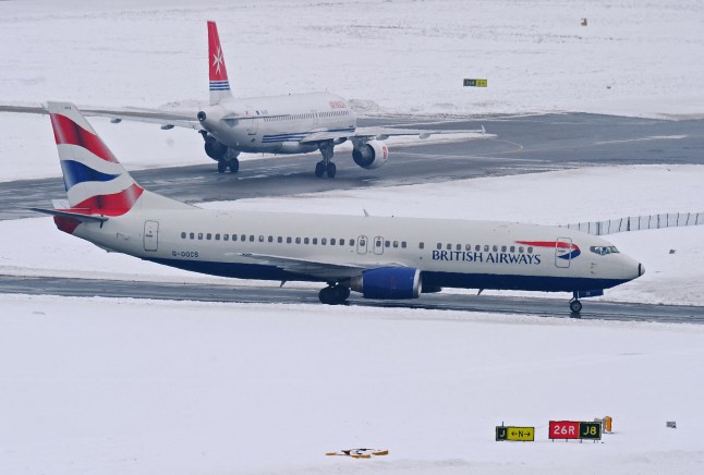 Photo taken on December 19, 2010 shows a British Airways plane surrounded by snow at Gatwick airport, West Sussex. Britain was hit by more blizzards that shut its biggest airports on the busiest weekend for travellers before Christmas and hit road and rail traffic. Gatwick airport said it was providing beds and cots, distributing thousands of blankets, hundreds of bottles of water and food and making showers and washing facilities available free of charge. AFP PHOTO / Carl de Souza (Photo by Carl DE SOUZA / AFP) (Photo by CARL DE SOUZA/AFP via Getty Images)