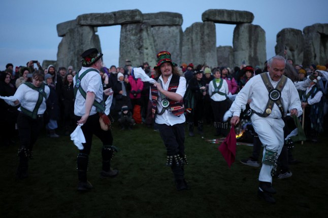 Morris dancers perform as people attend winter solstice celebrations at Stonehenge stone circle near Amesbury, Britain, December 21, 2025. REUTERS/Isabel Infantes