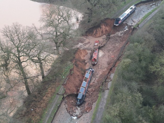 Handout photo issued by Shropshire Fire and Rescue Service of the scene in Whitchurch, Shropshire, where emergency services have declared a major incident after receiving reports at 4.22am this morning of a sinkhole causing large volumes of water to escape onto land in the Chemistry area of Whitchurch. Ten people have been helped to safety after a 50-metre-long sinkhole breached a canal in Shropshire, leaving several narrow boats stranded. Picture date: Monday December 22, 2025. PA Photo. Photo credit should read: Shropshire Fire and Rescue Service/PA Wire NOTE TO EDITORS: This handout photo may only be used in for editorial reporting purposes for the contemporaneous illustration of events, things or the people in the image or facts mentioned in the caption. Reuse of the picture may require further permission from the copyright holder.