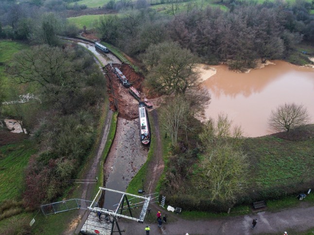 The scene in Whitchurch, Shropshire, where emergency services have declared a major incident after receiving reports at 4.22am this morning of a sinkhole causing large volumes of water to escape onto land in the Chemistry area of Whitchurch. Ten people have been helped to safety after a 50-metre-long sinkhole breached a canal in Shropshire, leaving several narrow boats stranded. Picture date: Monday December 22, 2025. PA Photo. Photo credit should read: Andy Kelvin/PA Wire