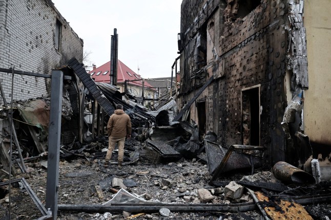 A man stands at the site where a Russian drone struck a residential building during a night of Russian drone and missile attacks, amid Russia's attack on Ukraine, in Kyiv, Ukraine December 27, 2025. REUTERS/Thomas Peter