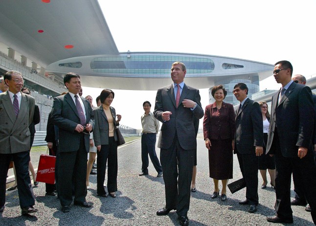 SHANGHAI, CHINA: Britian's Prince Andrew (C) is surrounded by local officials while visiting the Shanghai International Formula One Circuit in Shanghai, 20 April 2004. Britain's Prince Andrew is in China on a six-day mission looking to boost trade and investment with China. AFP PHOTO/LIU Jin (Photo credit should read LIU JIN/AFP via Getty Images)