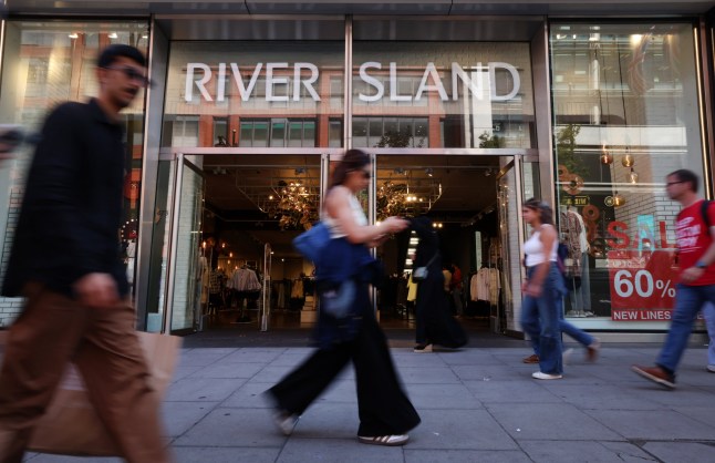 Shopper pass by a River Island shop on the high street