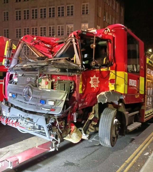 A smashed fire engine, with the front roof caved in, after colliding with another fire engine