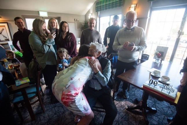 Brian and Carly embrace after being reunited nearly 40 years after he saved her life. // A retired firefighter was left stunned on his 90th birthday when he was reunited with the baby girl whose life he saved 40 years ago. Brian Passmore, who spent more than 25 years with the Lancashire Fire Service, never forgot that fateful day in 1986 when he rescued baby Carly Holden from a burning home in Blackpool, Lancs. Now a mum-of-five, Carly had kept cuttings of the rescue for decades - but she and Brian had never met until his milestone birthday party. Brian, who now lives in a care home, thought he was heading out for a quiet lunch at a nearby pub with his daughter Julie Henderson to celebrate the big day. Photo released 05/01/2026