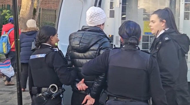 Back of a woman in handcuffs and surrounded by female police officers