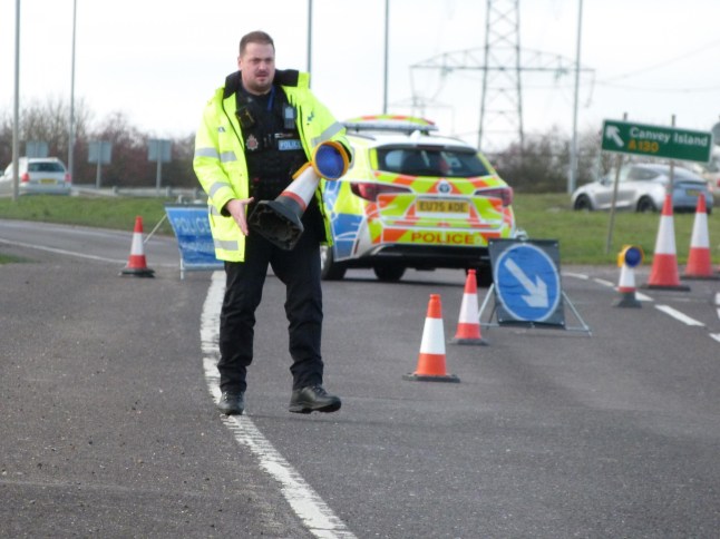 Police setting up road cordon with cones on the A130 in Essex.